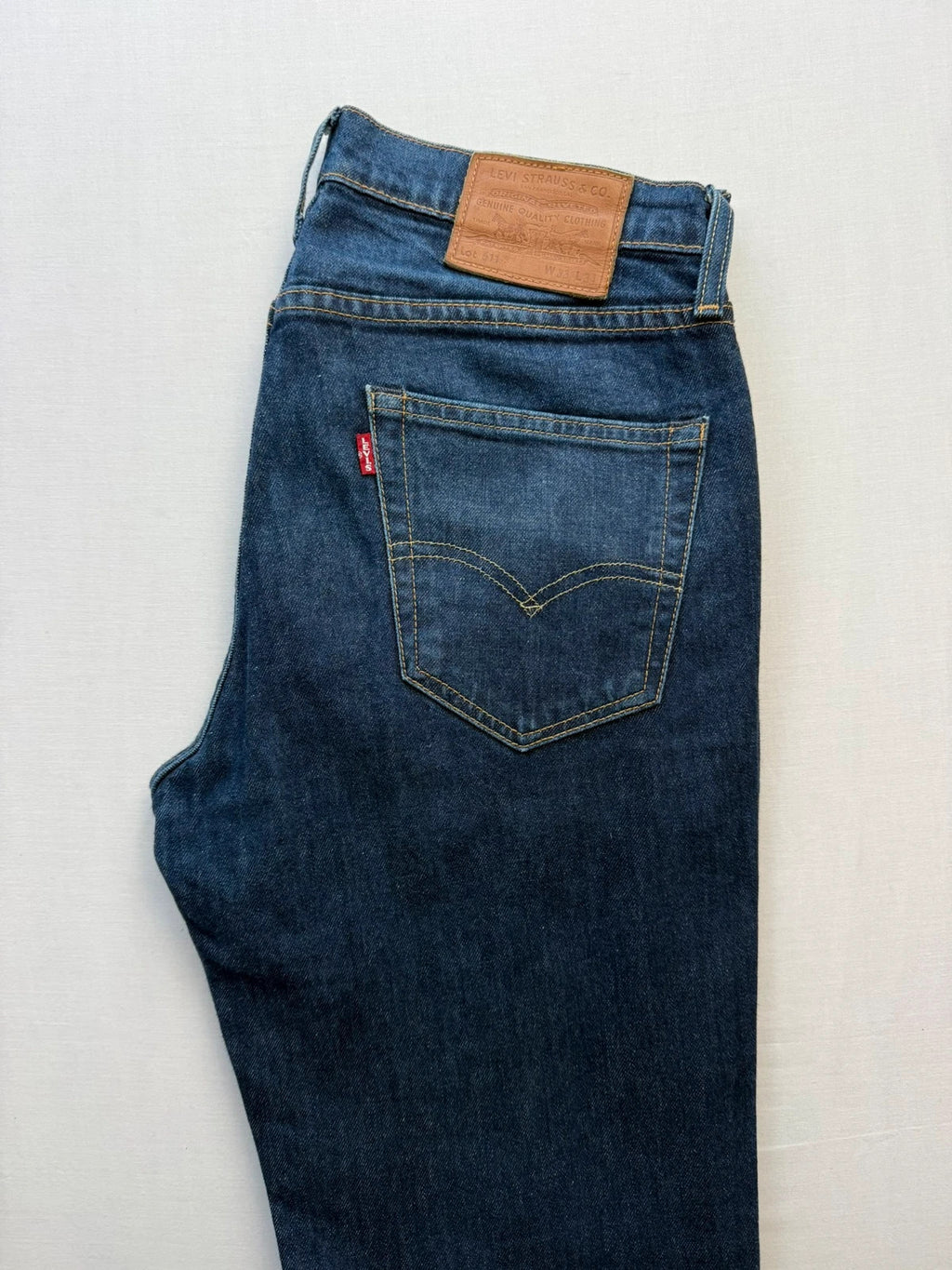 Levi's dark indigo slim fit jeans with leather back patch and red tab detail.