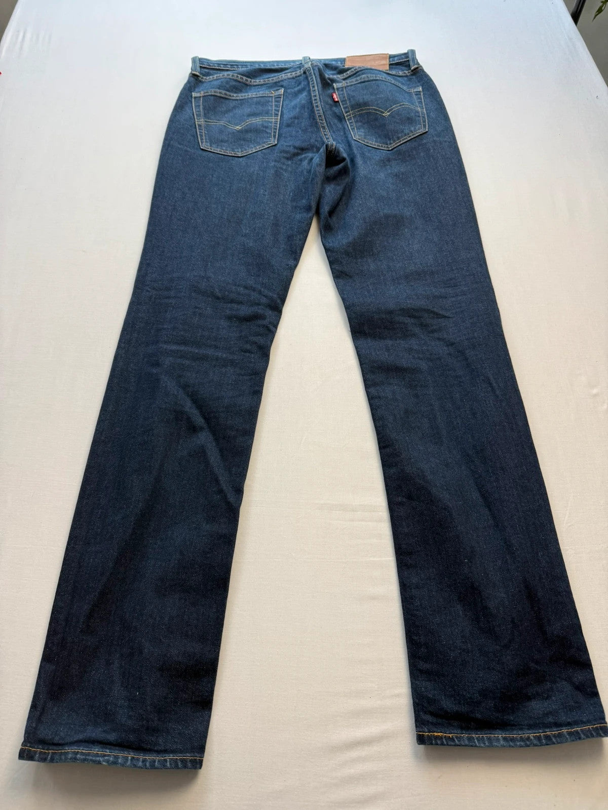 Levi's dark indigo slim fit jeans with leather back patch and red tab detail.