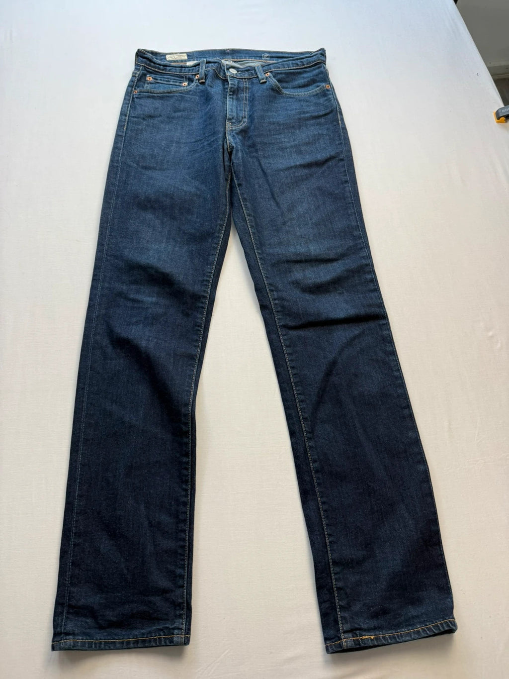 Levi's dark indigo slim fit jeans with leather back patch and red tab detail.