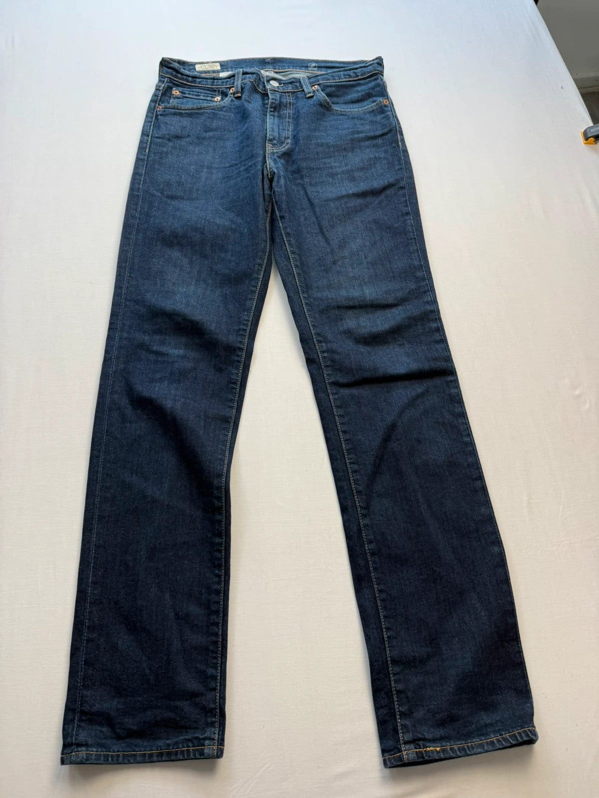 Levi's dark indigo slim fit jeans with leather back patch and red tab detail.