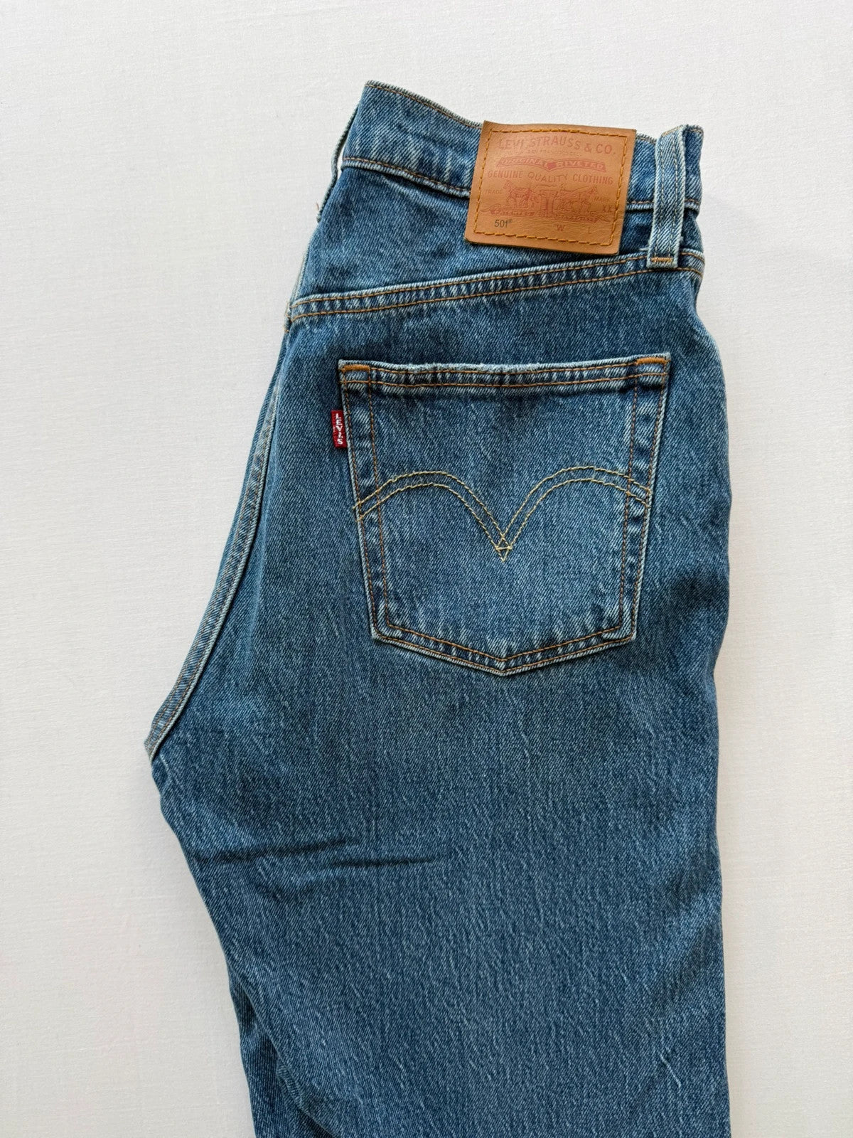 Levi's mid blue straight jeans with button fly and leather-look back patch.
