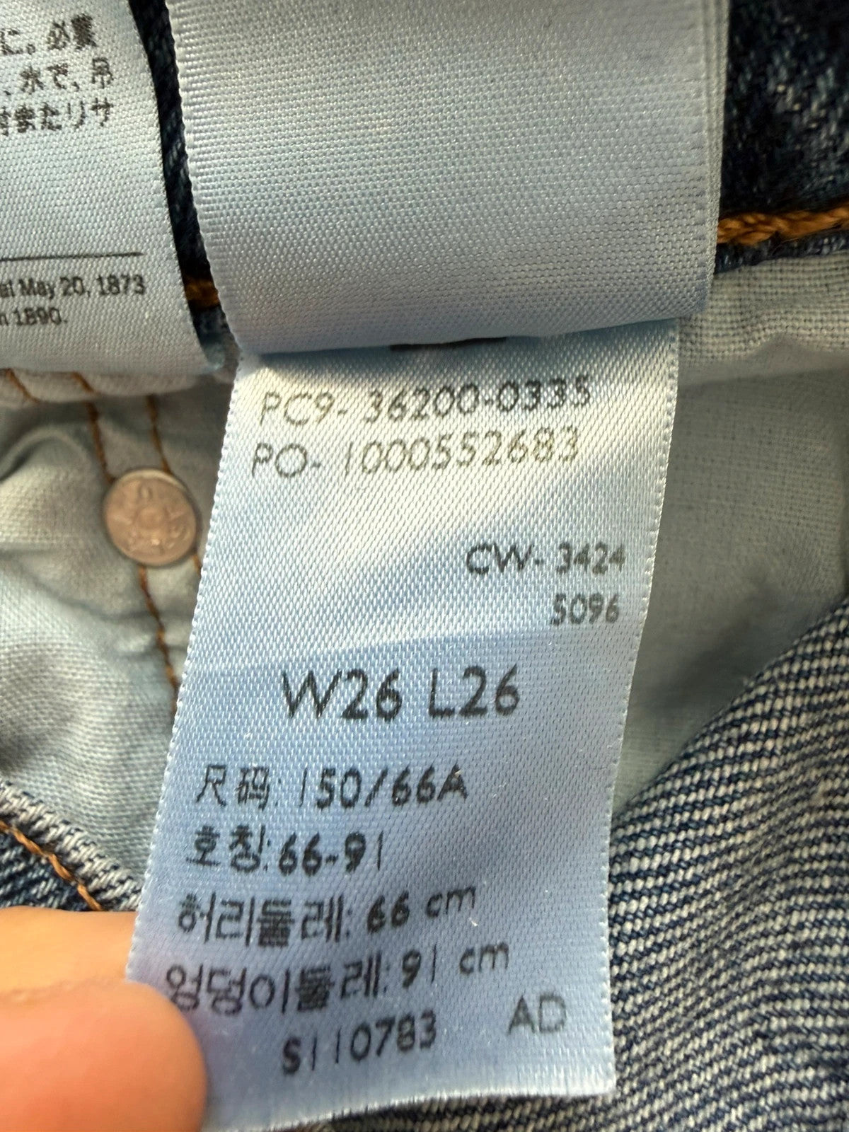 Levi's mid blue straight jeans with button fly and leather-look back patch.