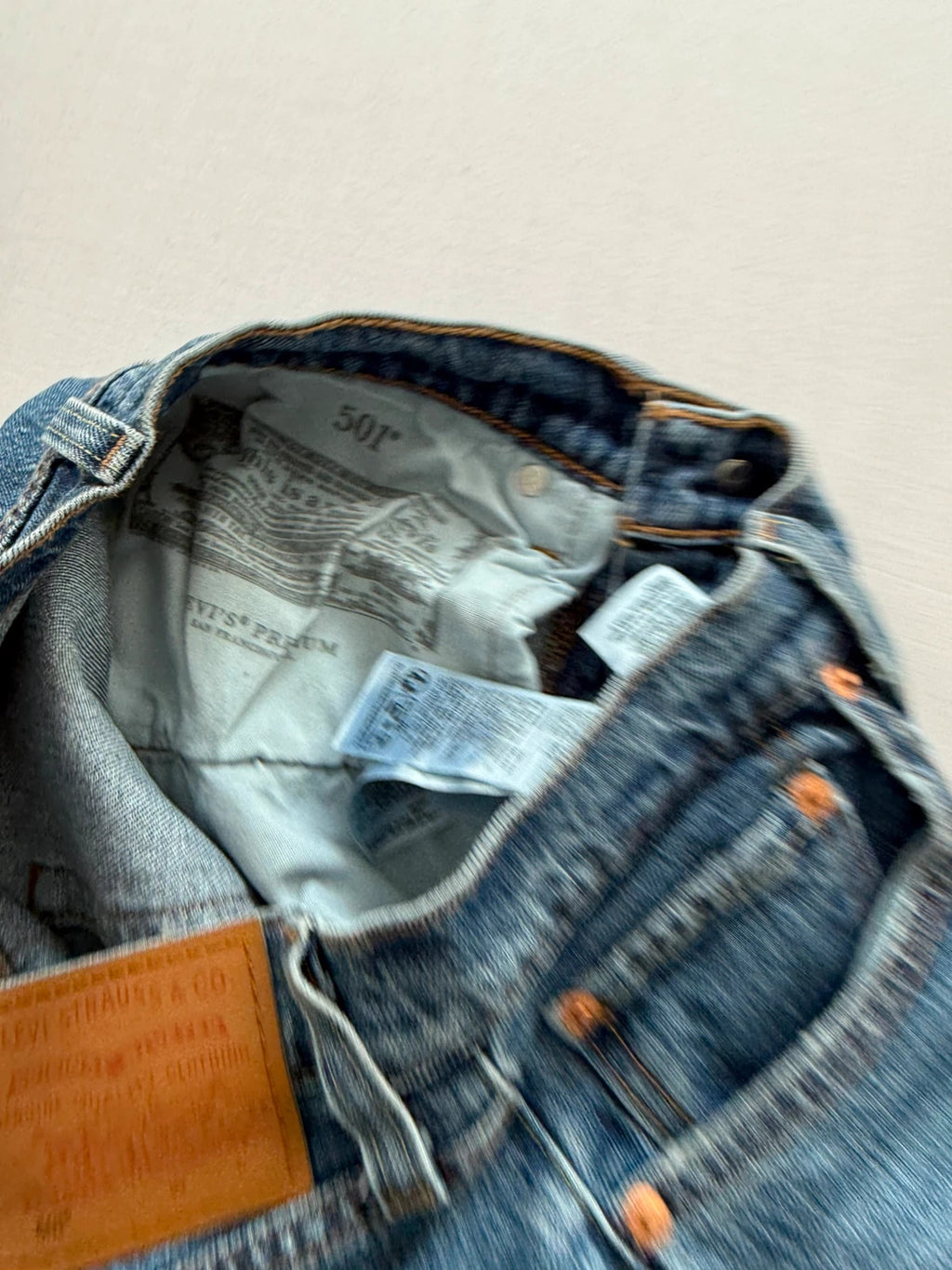 Levi's mid blue straight jeans with button fly and leather-look back patch.