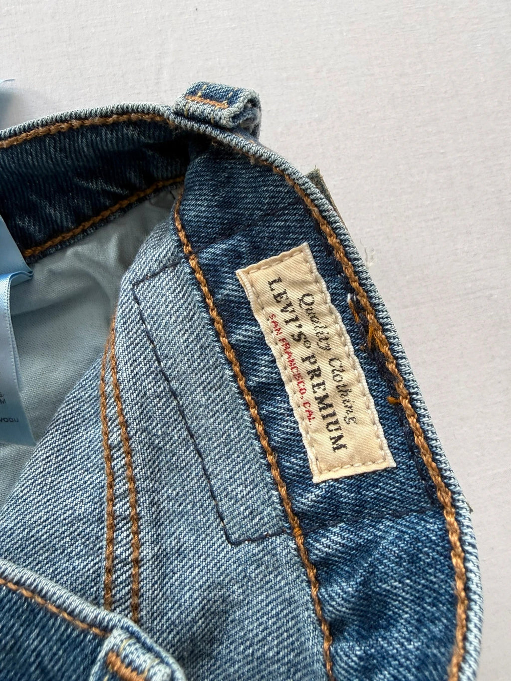 Levi's mid blue straight jeans with button fly and leather-look back patch.