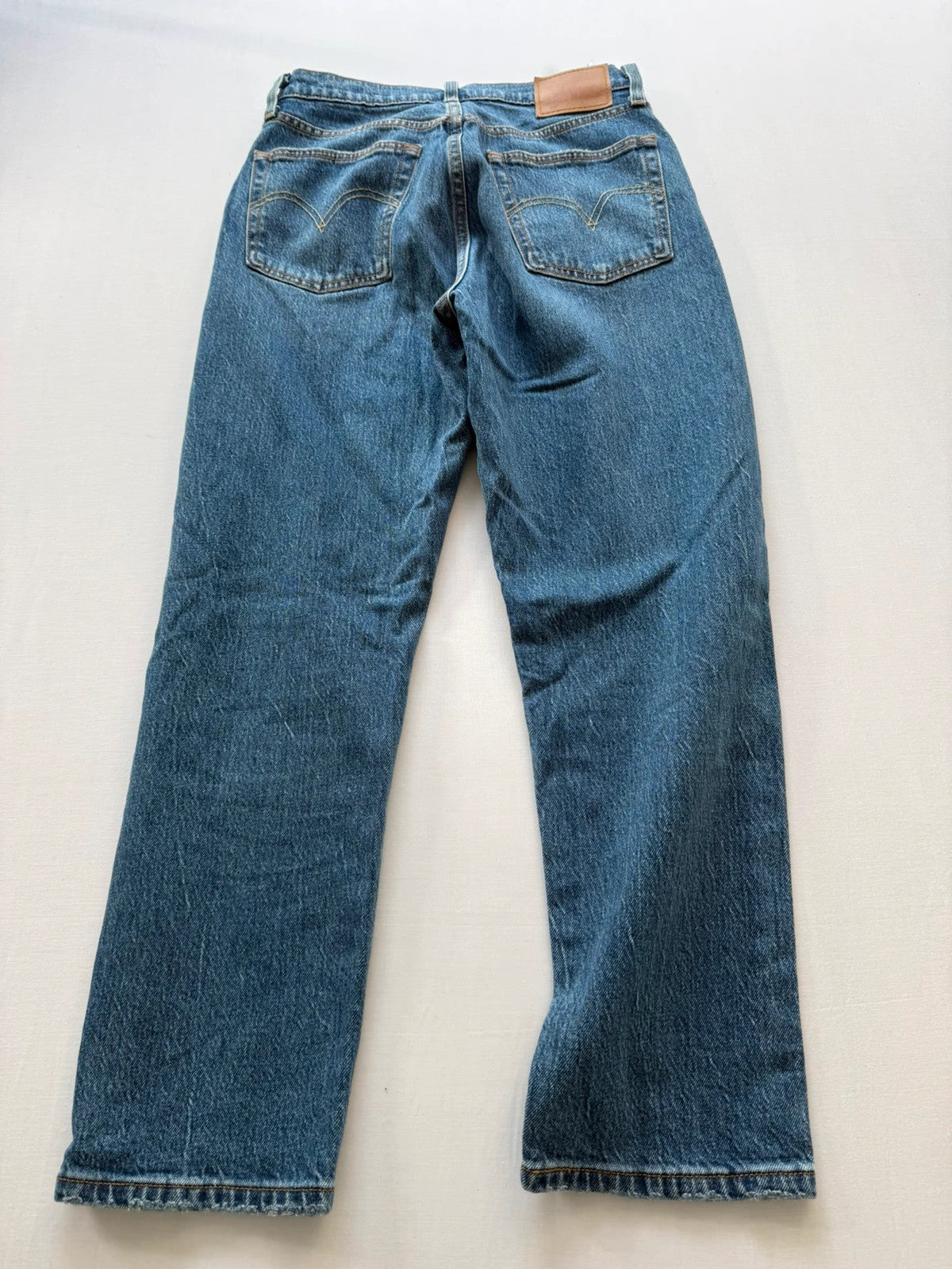 Levi's mid blue straight jeans with button fly and leather-look back patch.