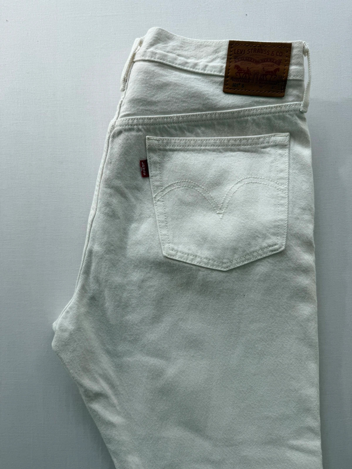 Levi's cream high rise skinny jeans with button fly and rigid cotton denim.