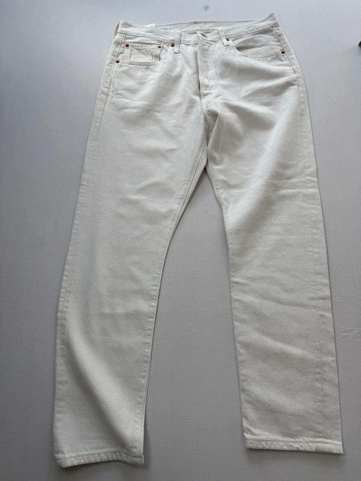 Levi's cream high rise skinny jeans with button fly and rigid cotton denim.