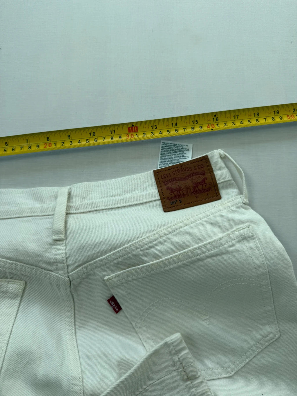 Levi's cream high rise skinny jeans with button fly and rigid cotton denim.